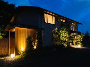 una casa iluminada por la noche con luces en 八海 木花館 en Oshino