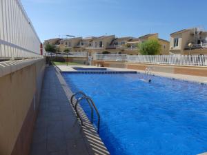 a large swimming pool with a person in the water at Bungalow moderno luminoso terraza solarium patio - PISCINA COMUNITARIA in Puerto Marino