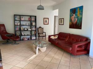 un soggiorno con divano rosso e tavolo in vetro di L’échappée belle a Entre-Deux