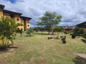 un parco di fronte a un edificio con palme di Lindo e confortável Flat Em Gravatá a Gravatá