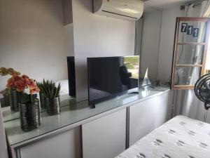 una TV a schermo piatto seduta sopra un bancone di Lindo e confortável Flat Em Gravatá a Gravatá