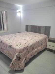 Un dormitorio con una cama con una manta rosa. en Casa do Bosque 87, en Gramado