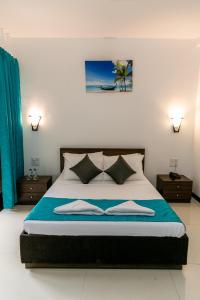 a bedroom with a large bed with two night stands at Aloha Holiday Resort in Baga