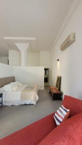 1 dormitorio con 1 cama y 1 sofá rojo en Vivaterra Apartments - San Telmo en Buenos Aires