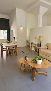 - un salon avec deux tables et un canapé dans l'établissement Vivaterra Apartments - San Telmo, à Buenos Aires