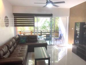 a living room with a couch and a ceiling fan at Sabbia Playa Downtown Condo in Playa del Carmen