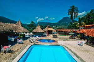 Hotel Hacienda la Bonita في Amagá: مسبح في منتجع فيه جبال في الخلف