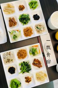 dwie białe płytki wypełnione różnymi rodzajami żywności w obiekcie Yi Piao B&B w mieście Zhushan