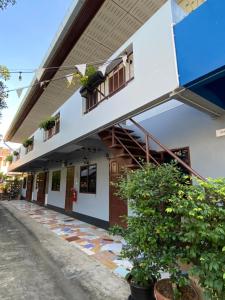 un edificio blanco con balcón y algunas plantas en Baan Nukanong Guesthouse en Chiang Rai