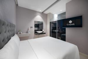 a bedroom with a white bed and a bathroom at Mari Hotel By Connek in Ho Chi Minh City