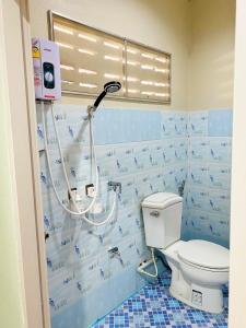 La salle de bains est pourvue de toilettes avec un cintre sur le mur. dans l'établissement Baan Nukanong Guesthouse, à Chiang Rai