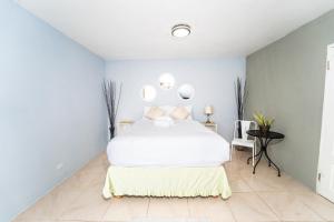 1 dormitorio con cama blanca y espejos en la pared en Skyline Suites 2 Queen bedroom condo en Montego Bay