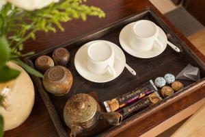 una bandeja con dos tazas y platillos en una mesa en Dali Yanyuan Mountain Retreat, en Dali