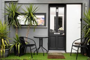 a patio with a black door and chairs and plants at Sherrard Spacious Family Place in Nerrina