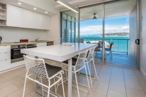 a kitchen with a table and chairs and a balcony at One Bright Point - Stunning Water Views in Nelly Bay