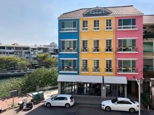 two cars parked in front of a colorful building at New Color River in Tainan