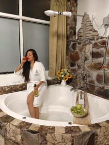 a woman sitting in a bath tub talking on a cell phone at Cities of the World - Apartments Cusco in Cusco