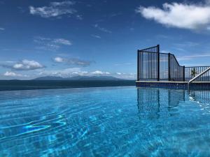 a large pool of water with a fence on it at One Bright Point - Stunning Water Views in Nelly Bay