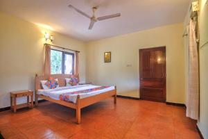 una camera con letto e ventilatore a soffitto di Amazing Hilltop 3BHK Villa with Swimming Pool a Goa Velha