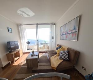 a living room with a couch and a large window at Euromarina 2 Reñaca Vista al Mar in Viña del Mar