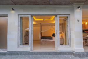 a view of a bedroom with a bed through a glass door at The Dayuh Ubud in Ubud