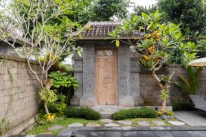 a small house with a wooden door in a garden at The Dayuh Ubud in Ubud +36 photos