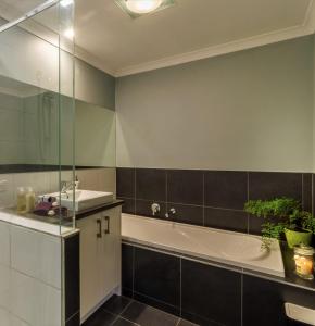 uma casa de banho com uma banheira e um lavatório em Torquay Homestay Guesthouse em Torquay