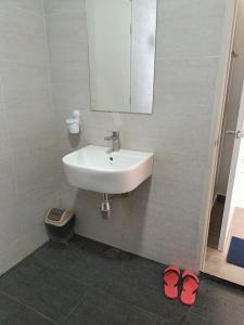 W łazience znajduje się umywalka, lustro i 2 kapcie. w obiekcie BR Troika Homestay w mieście Kota Bharu