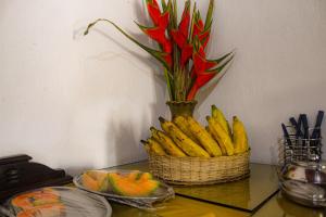 una cesta de plátanos en una mesa con una flor en Casarão dos Uchoa, en Guaramiranga
