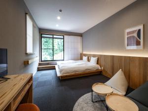 a bedroom with a bed and a tv in a room at 別府ホテル塒 Beppu Hotel Negura in Beppu