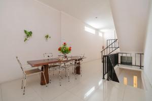 a dining room with a wooden table and chairs at RedDoorz At Fella Homestay Medan in Medan