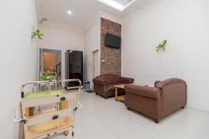 a living room with two chairs and a table at RedDoorz At Fella Homestay Medan in Medan