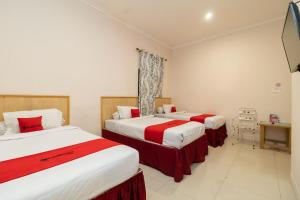 a hotel room with two beds and a television at RedDoorz At Fella Homestay Medan in Medan