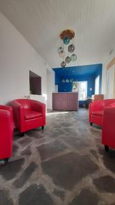 a large room with red furniture and a blue wall at Logis Hôtel Restaurant Le 1050 in Saint-Agrève