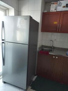a kitchen with a refrigerator and a sink at GRACE BEDSPACE, HOSTEL AND ACCOMODATIONS in Dubai