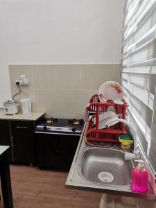 eine Küchenspüle mit einem Geschirrständer in der Unterkunft Mahren Homestay - Homestay Merlimau Serkam Melaka 