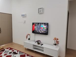 uma sala de estar com televisão numa parede branca em Mahren Homestay - Homestay Merlimau Serkam Melaka 