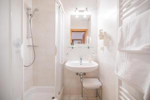 a white bathroom with a sink and a shower at Residence Villa Maria in Sesto