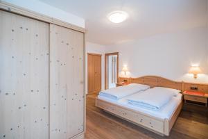 een slaapkamer met een groot wit bed en houten vloeren bij Residence Villa Maria in Sesto