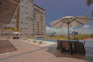 a patio with a table and an umbrella and a pool at City View at The Persimmon Studios in Cebu City