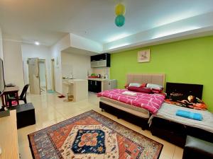 een slaapkamer met een bed en een groene muur bij Private Studio Viana Court Service Apartment 2 with private parking in Kota Bharu