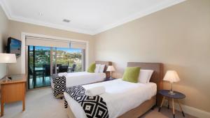 Duas camas num quarto com varanda em Unit 40 - 4 Bed Part Ocean View em Terrigal
