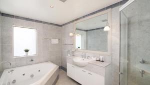 uma casa de banho com uma banheira e um lavatório e uma banheira em Unit 40 - 4 Bed Part Ocean View em Terrigal