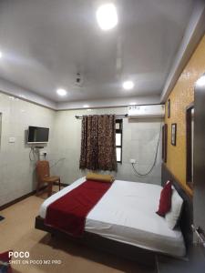 a bedroom with a bed and a tv in it at Hotel Geetanjali St Bus Stand Panvel in Panvel