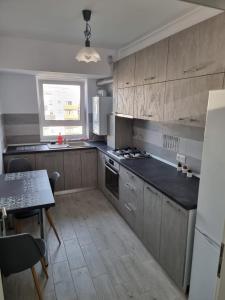 a kitchen with wooden cabinets and a table and a counter top at Best View Apartment in Braşov