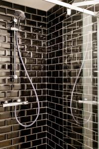 um chuveiro na casa de banho com uma parede de tijolos em Le Studio Émeraude - Topdestination-Spa em Spa