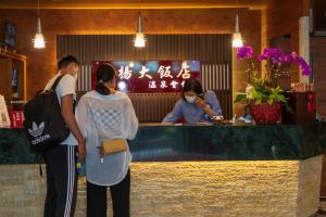 two women standing at a bar in a restaurant at Jenq Yang Hotspring Hotel in Renai