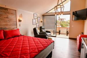 a bedroom with a red bed and a balcony at Ariels Paraiso- Ocean view in Primo Tapia