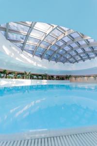 a large swimming pool with a glass roof at Hanza Tower De Lux apartament in Szczecin