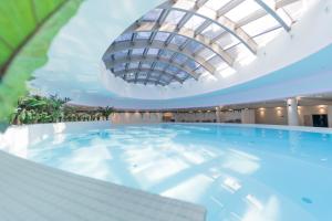 a large swimming pool with a domed ceiling at Hanza Tower De Lux apartament in Szczecin
